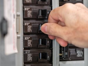Technician checks breaker as a step in troubleshooting a circuit