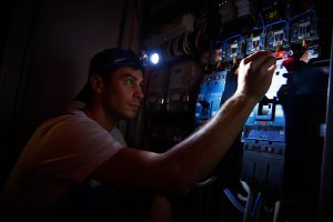 Electrician detecting and fixing wiring