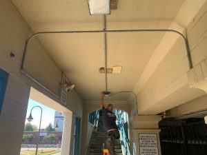 Technician preforms electrical maintenance on exit sign