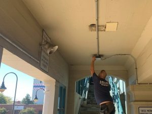 Technician preforms electrical maintenance on exit sign