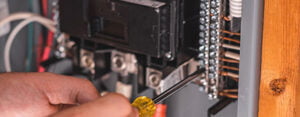 Technician tightens the screws in the electrical panel during an electrical inspection
